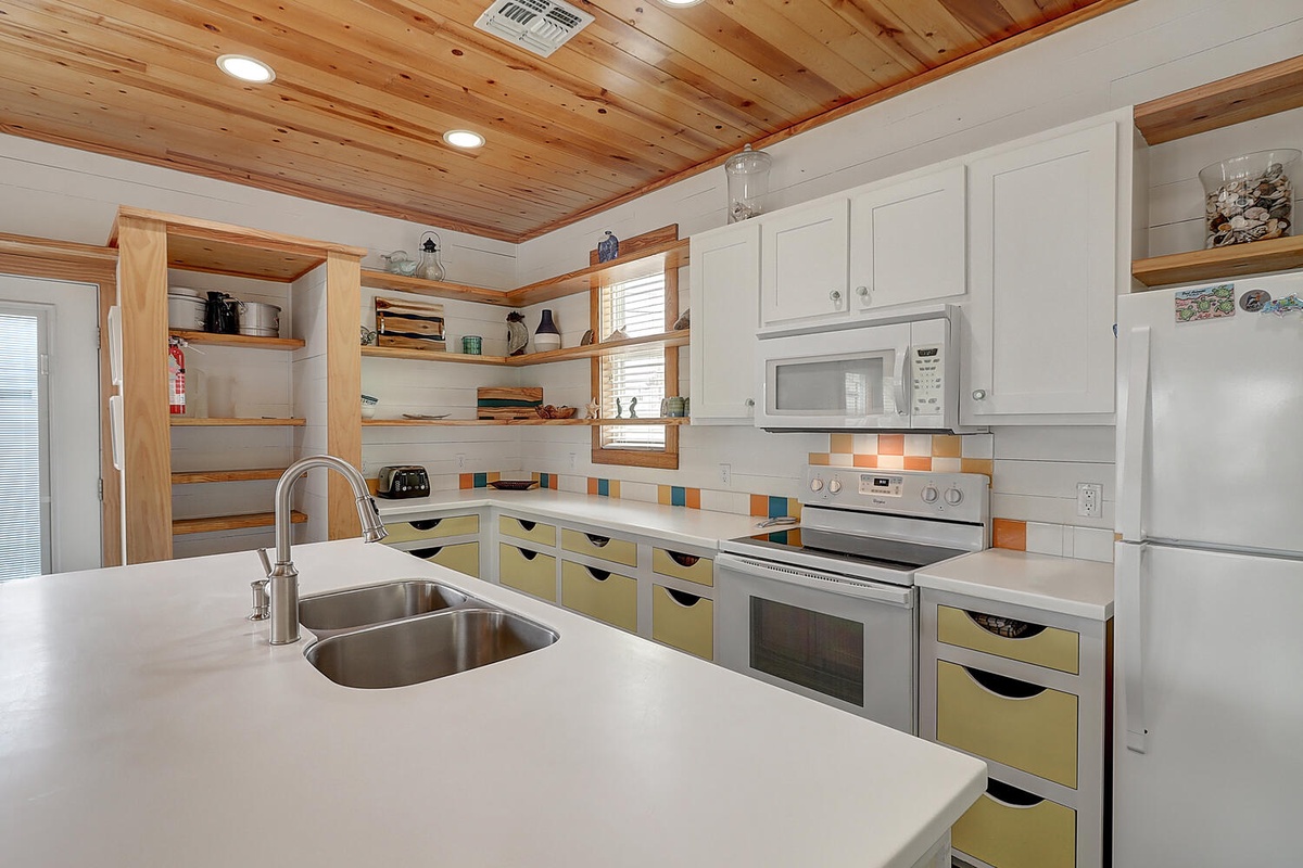 Your fully equipped kitchen features warm wood ceilings, colorful drawers, and everything you need to create memorable meals during your stay.