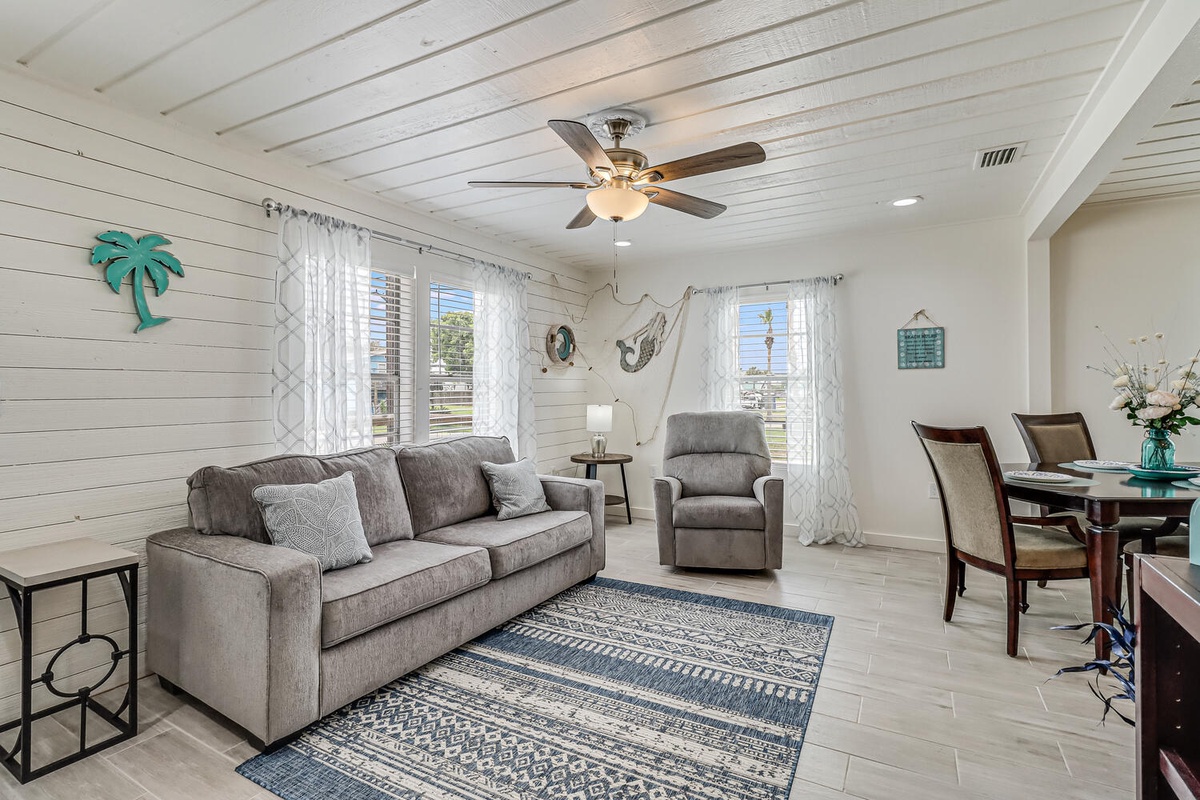 Relax in this bright coastal living space where shiplap walls and modern comfort create your perfect beach getaway retreat.