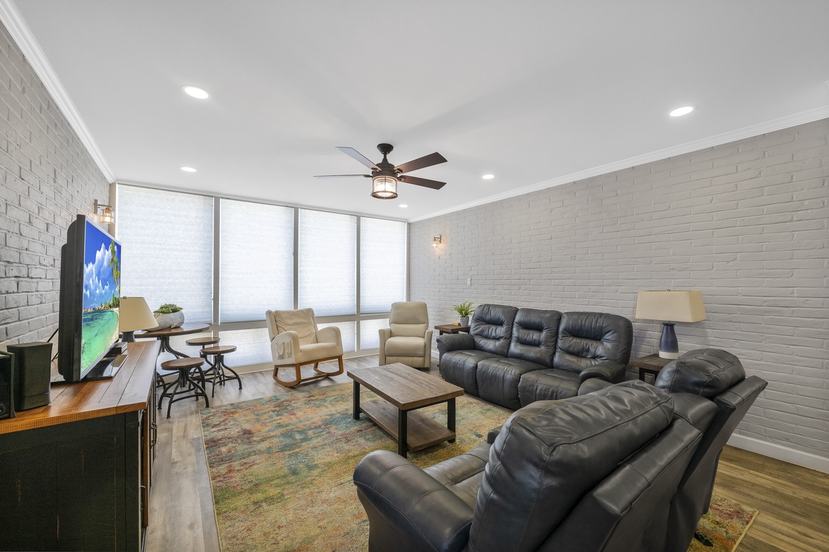 Sink into plush leather seating while enjoying your favorite shows on the large TV, surrounded by modern comfort and natural light.