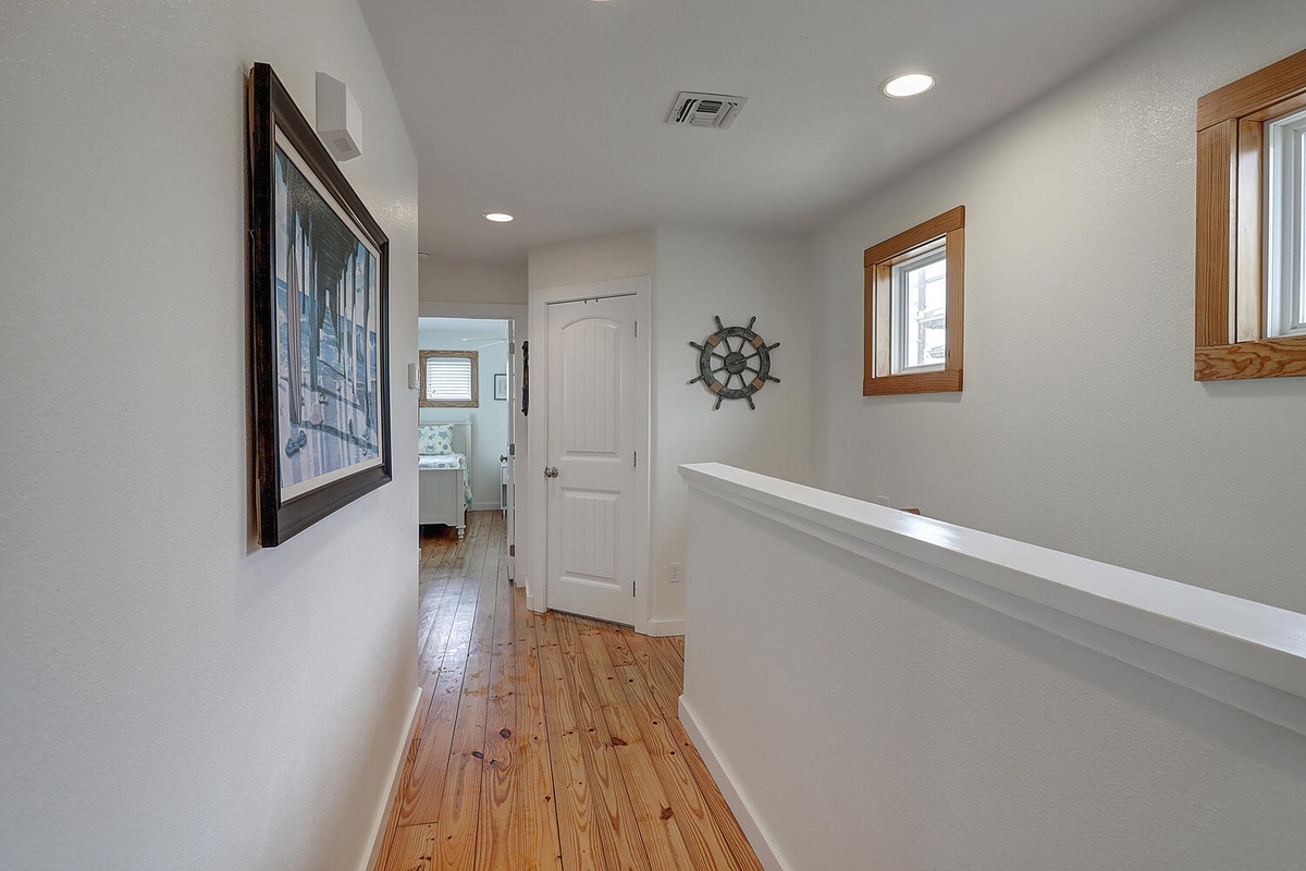 Walk through your bright hallway with beautiful hardwood floors and charming nautical touches that create a welcoming coastal atmosphere.