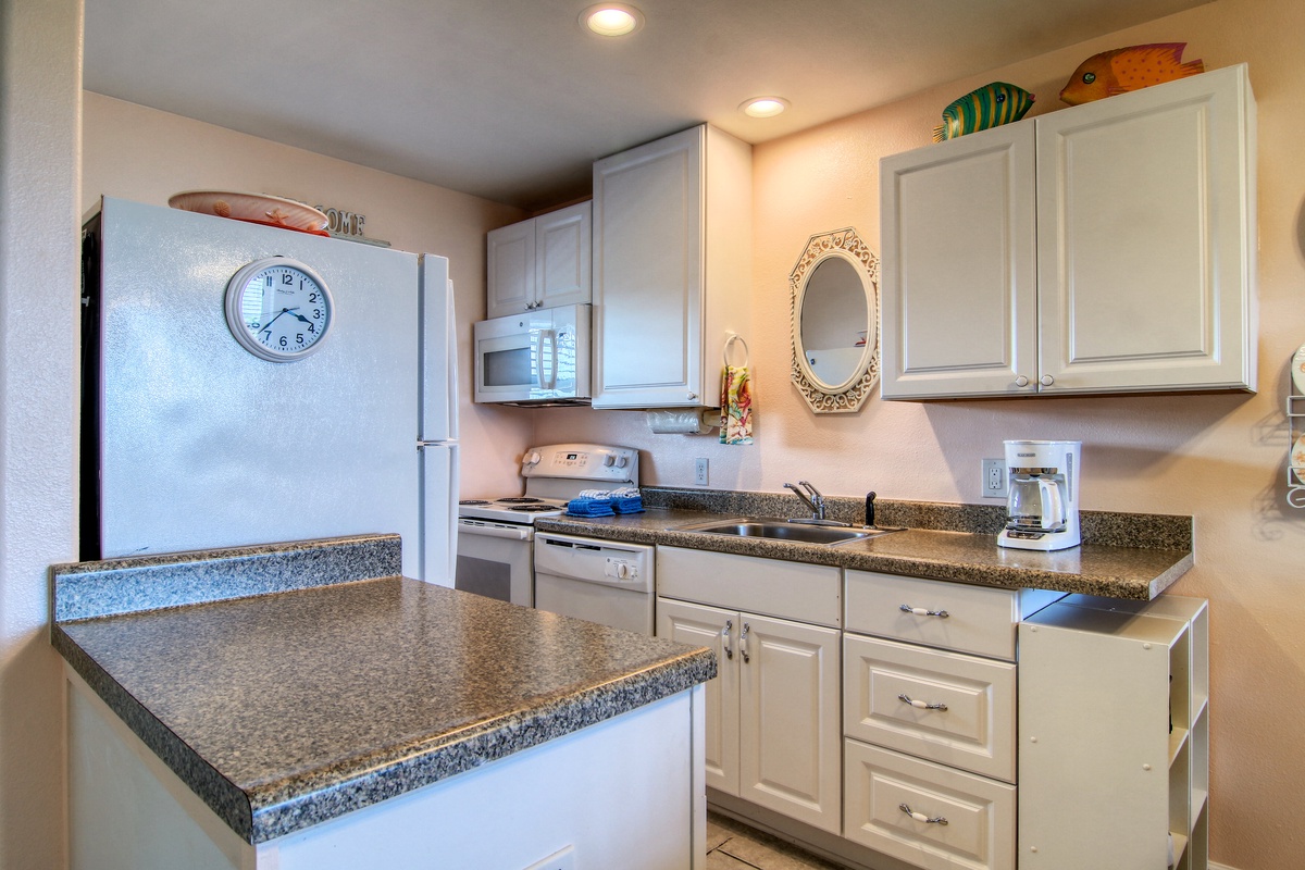 Your fully equipped kitchen features granite counters, white cabinets, and all appliances needed to prepare meals during your stay.