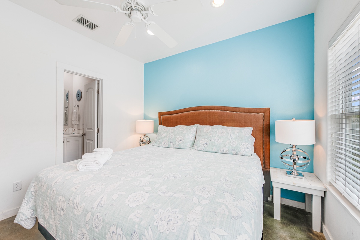 Wake up refreshed in your coastal-inspired bedroom, where the soothing turquoise accent wall creates the perfect backdrop for peaceful mornings.