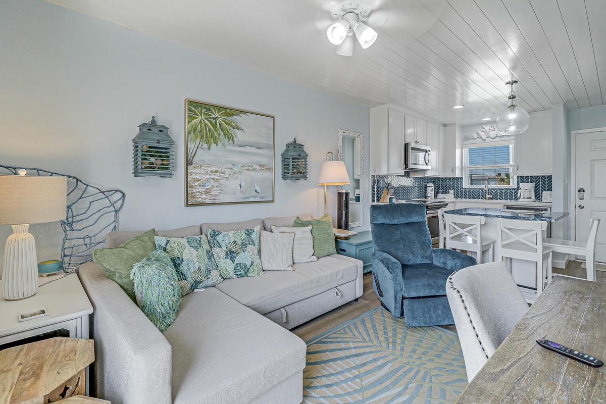 Sink into your coastal-inspired living space where ocean blues meet comfort. Unwind on plush seating while preparing meals in your stylish kitchen.