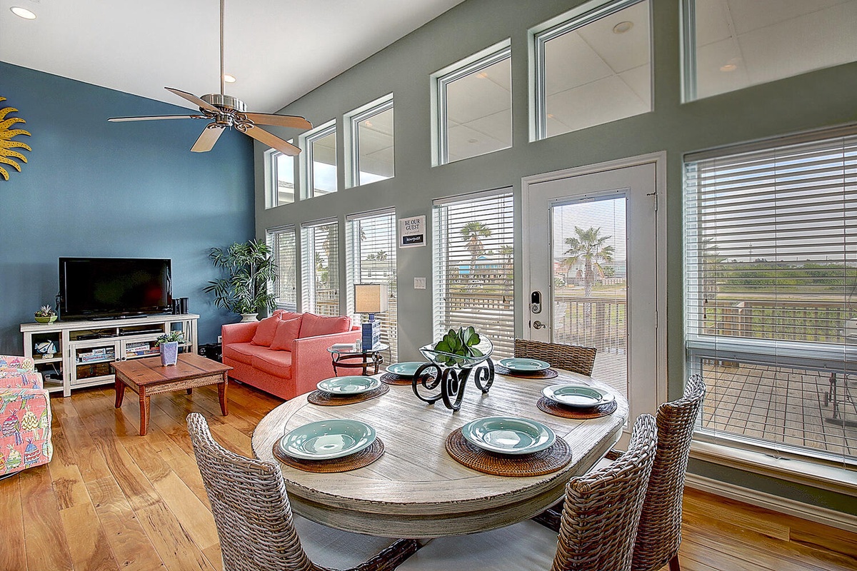 Relax in this bright, open living space where dining and lounging flow together seamlessly, with views of palm trees creating your perfect vacation atmosphere.