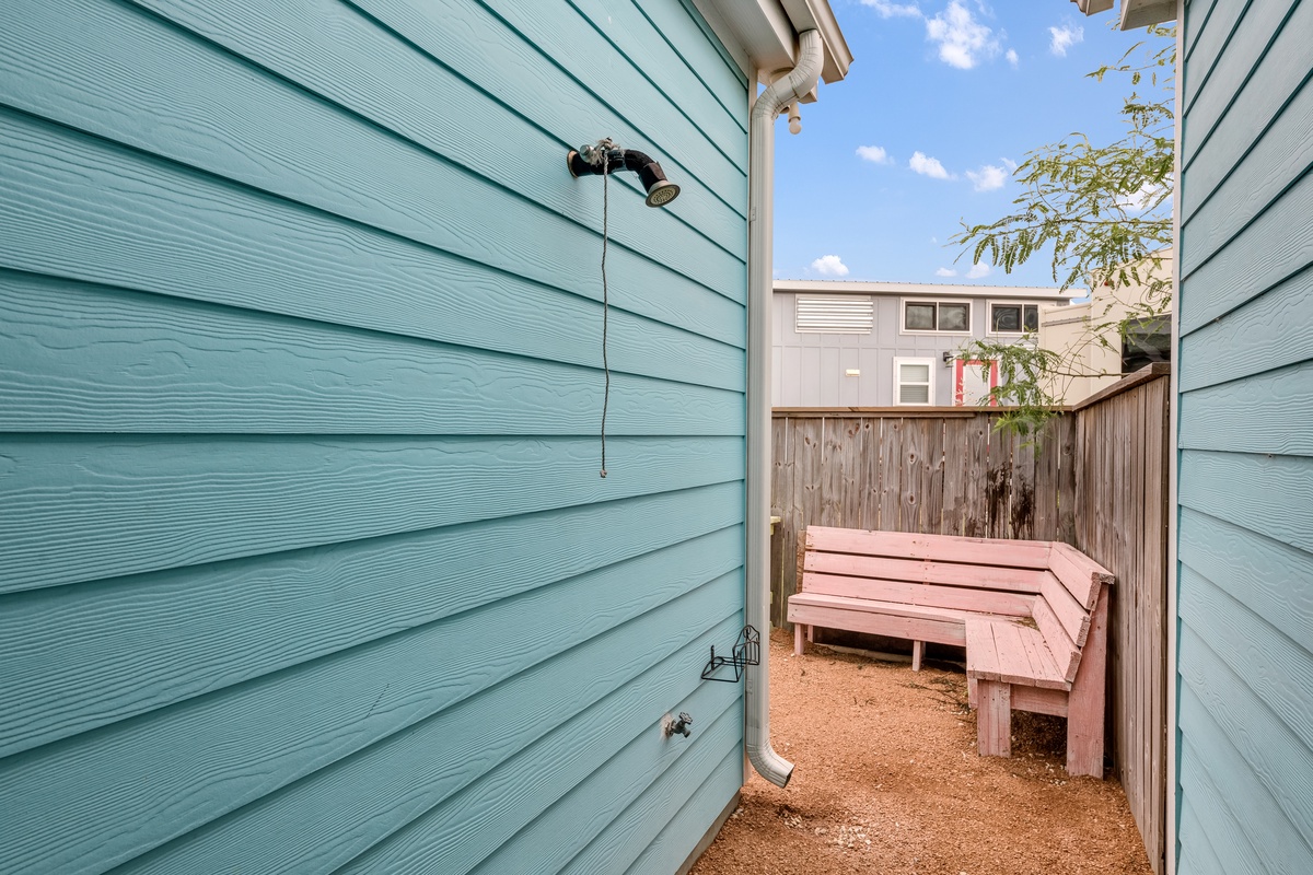 Step into your private outdoor sanctuary with rustic wooden seating surrounded by charming mint-green walls.
