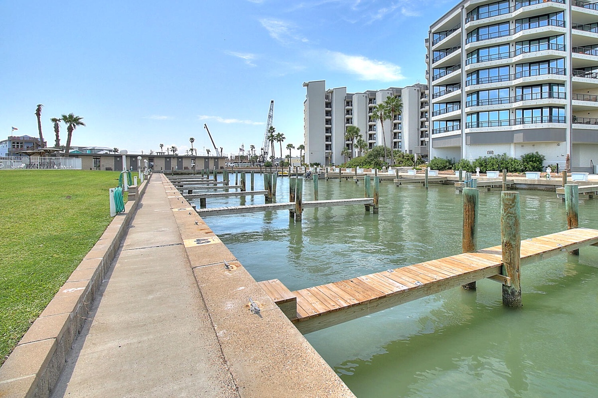 Waterfront community with private marina access, featuring residential buildings and boat docks along the peaceful canal.