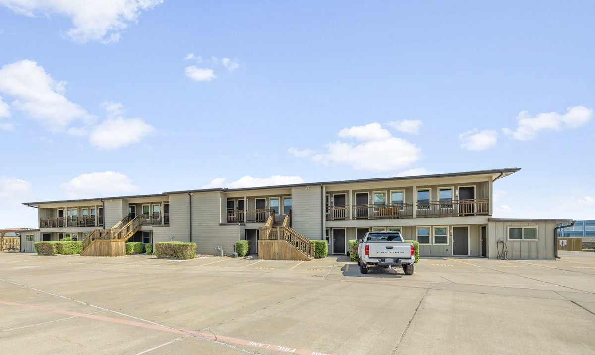 Modern two-story property building with convenient parking and easy access to each unit via exterior stairways.