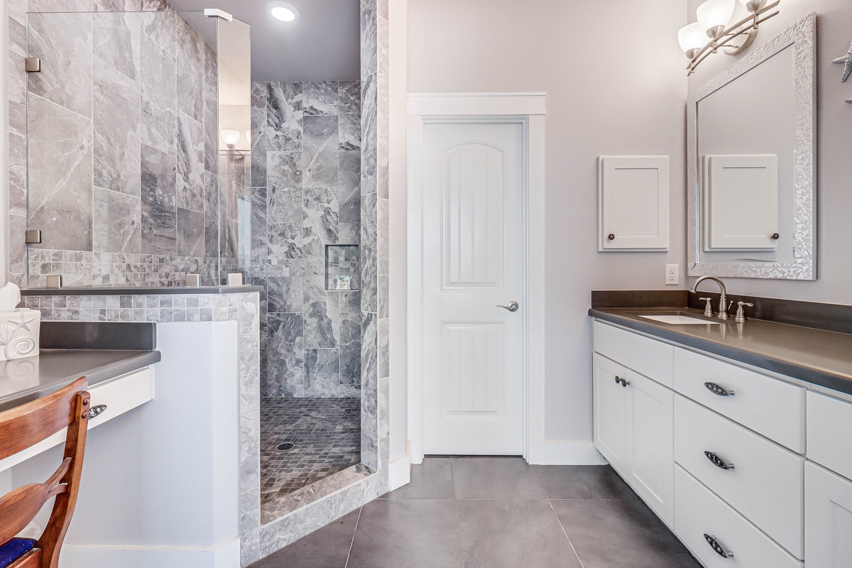 Unwind in your luxurious marble bathroom featuring elegant tiling and a spacious walk-in shower perfect for relaxation.