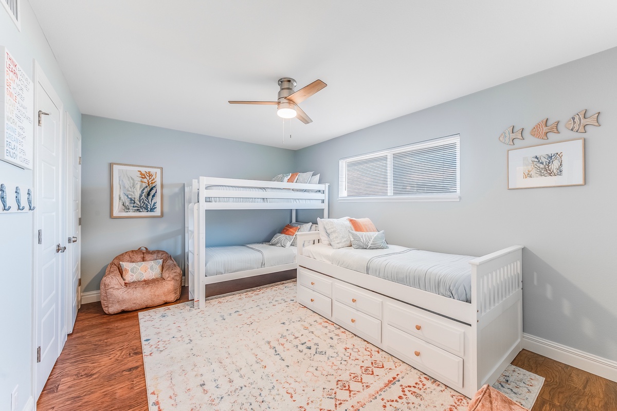 Your family will love this cheerful bedroom with bunk beds and trundle, perfect for kids' adventures and cozy bedtime stories.