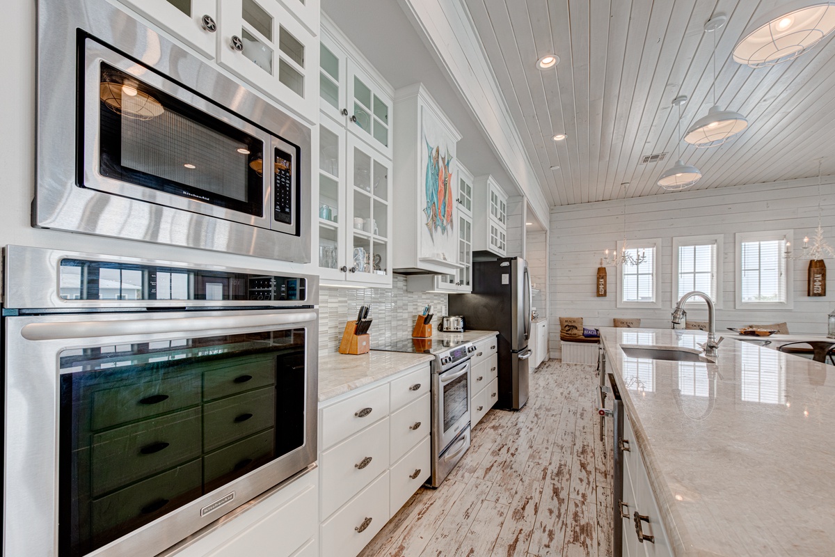 This stunning gourmet kitchen invites you to create memorable meals with professional appliances, granite counters, and charming coastal details.