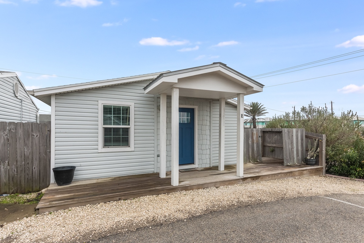Charming coastal cottage with covered porch and private parking for a peaceful beach getaway.