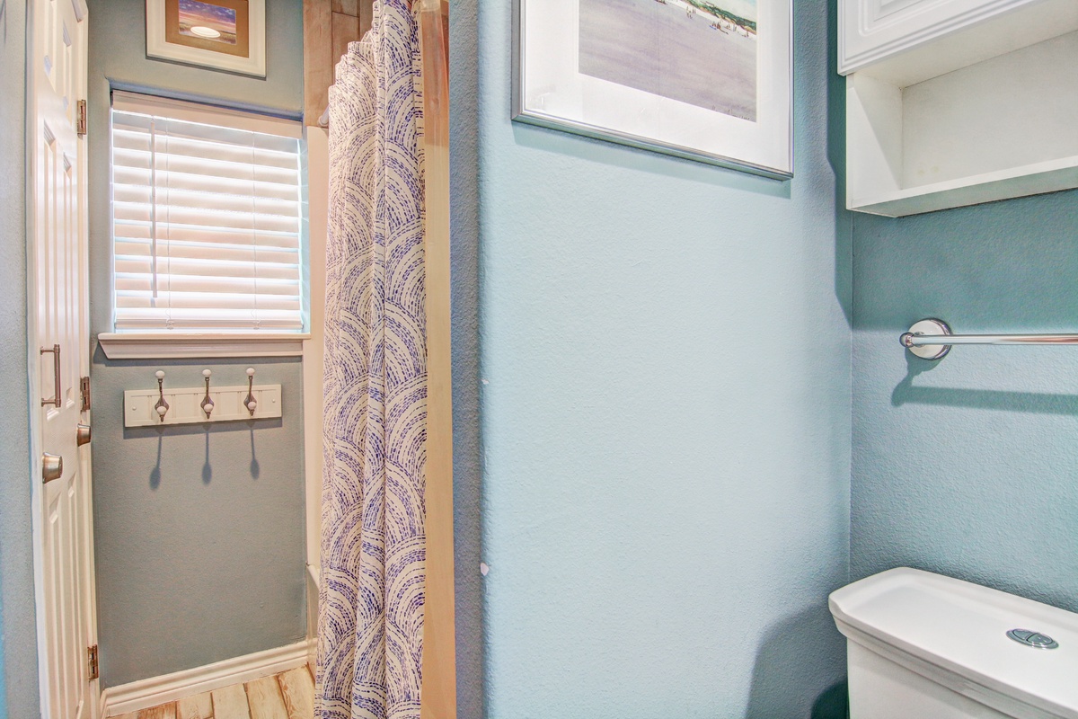 Step into your serene coastal bathroom where calming blue walls and charming artwork create a peaceful retreat after beach adventures.
