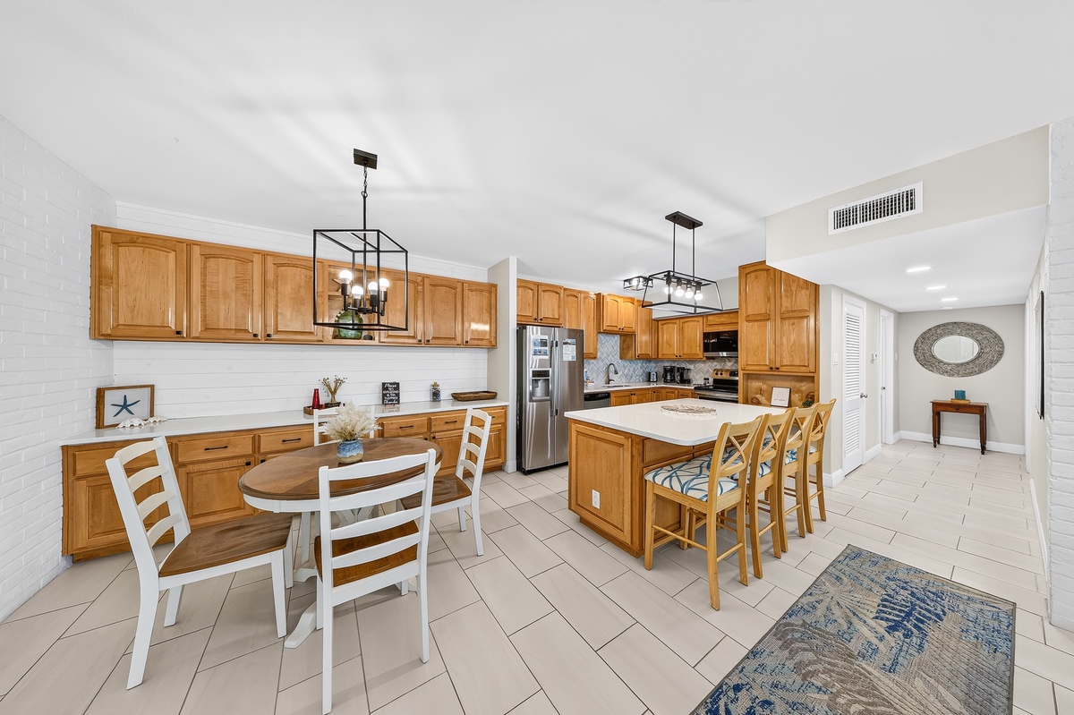 Gather around the spacious kitchen island for meals and laughter, with warm wood cabinetry, stainless appliances, and plenty of room to cook and connect.