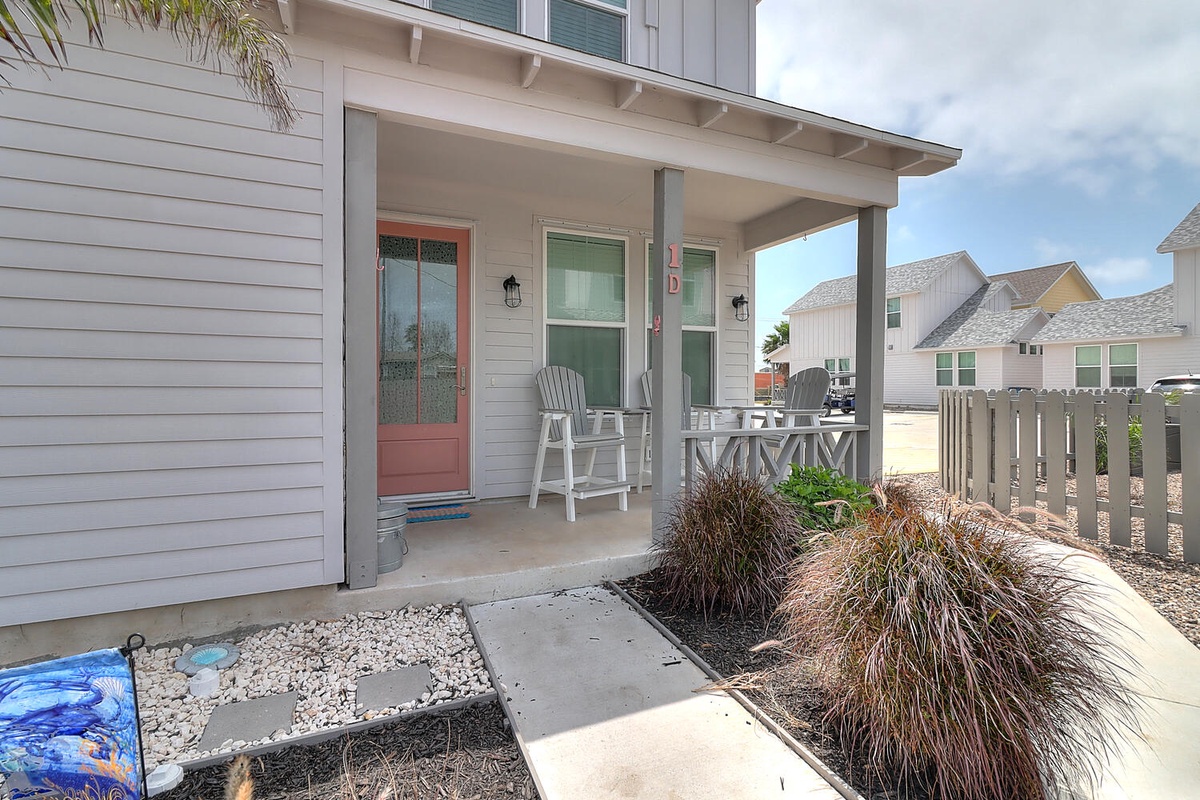 Welcoming front porch with comfortable seating where you can unwind after beach adventures in this charming coastal neighborhood.