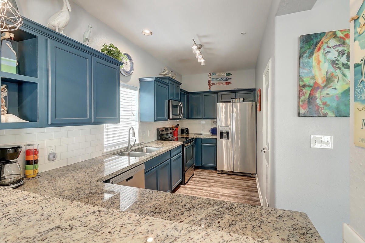 Your modern kitchen features stylish blue cabinets, granite countertops, and stainless appliances—perfect for preparing meals during your stay.