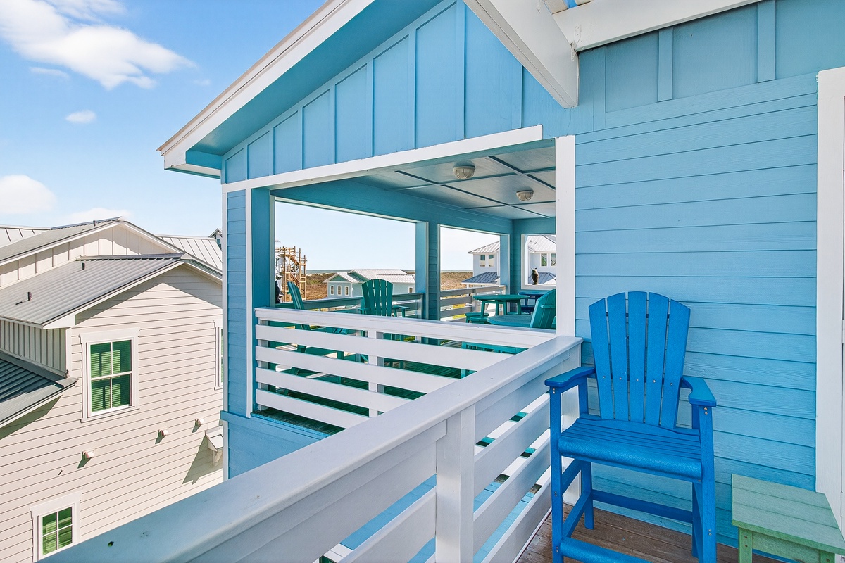 Soak up the coastal charm from your private balcony, where ocean breezes and bright blue Adirondack chairs invite peaceful mornings with coffee.