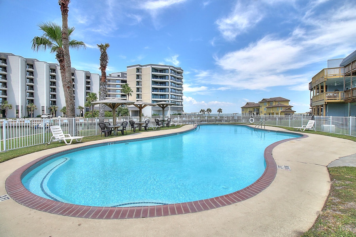Dive into crystal-clear waters surrounded by swaying palms and coastal charm at this inviting pool oasis.