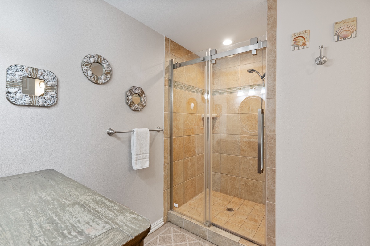 Step into your elegant glass-enclosed shower with beautiful tile work and modern fixtures for a refreshing start to your day.