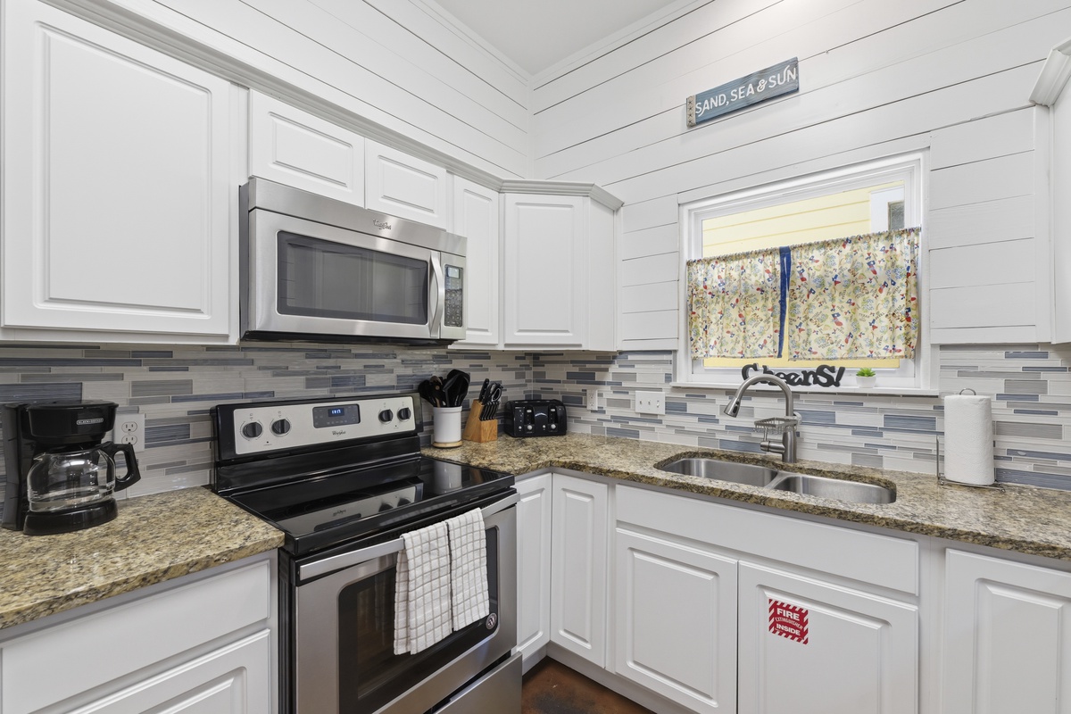 Your fully equipped kitchen awaits, complete with stainless steel appliances, granite countertops, and charming coastal-inspired decor to make meal prep a breeze.