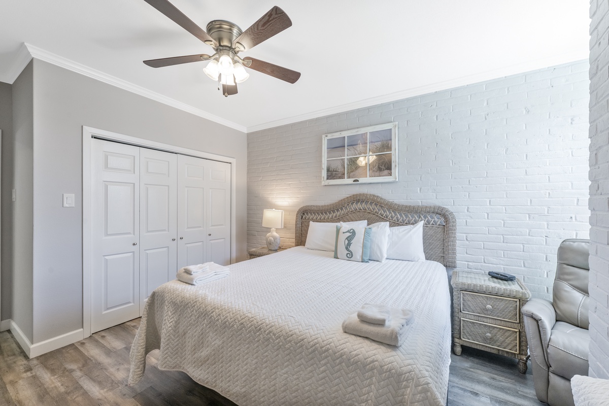 Drift off in your coastal-inspired bedroom with crisp white linens, charming wicker touches, and gentle ceiling fan breeze.