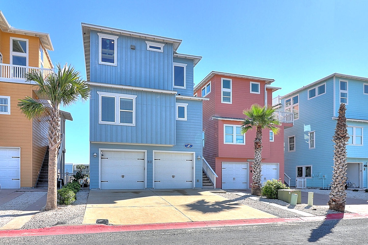 Colorful beach houses line this coastal neighborhood, featuring bright blue, coral, and yellow facades with palm trees and easy beach access.