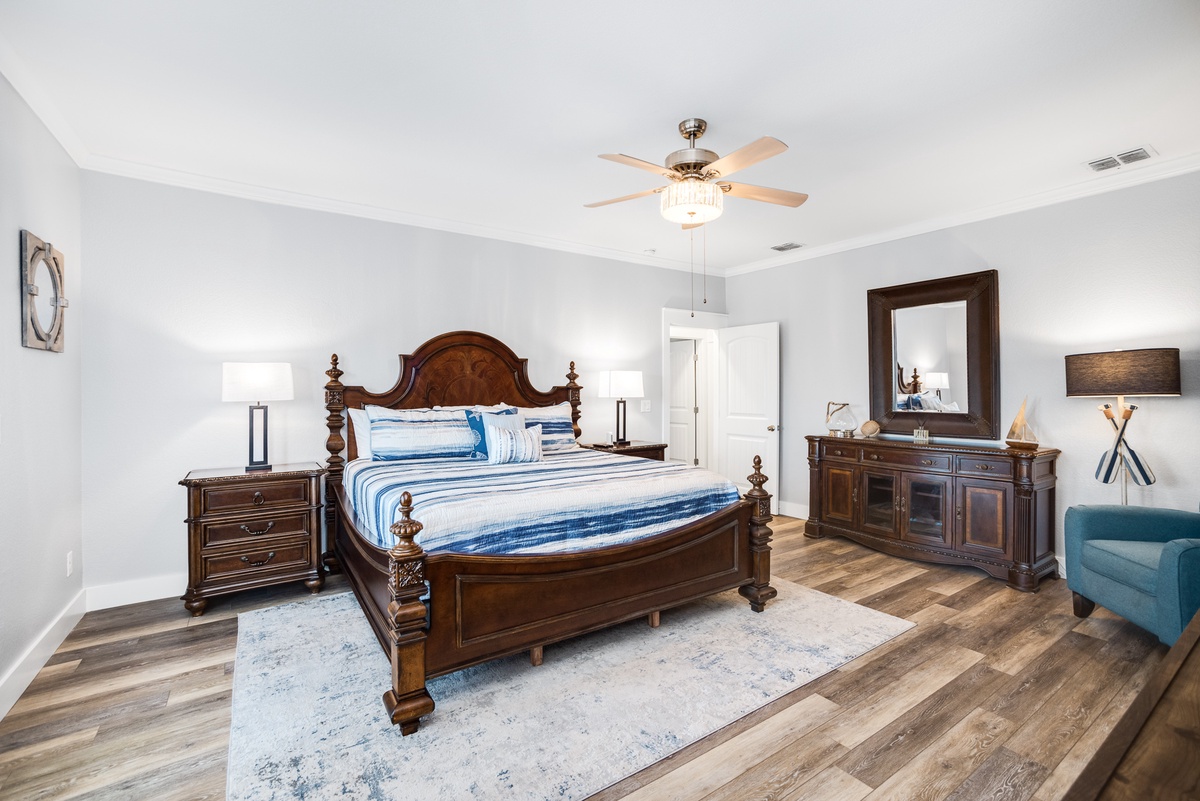 Unwind in your elegantly appointed master suite, where rich wood furnishings and coastal-inspired linens create a serene retreat for restful nights.