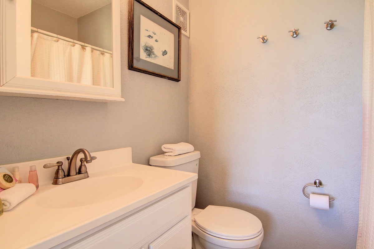 Step into your private bathroom featuring clean lines, thoughtful coastal artwork, and fresh towels ready for your arrival.