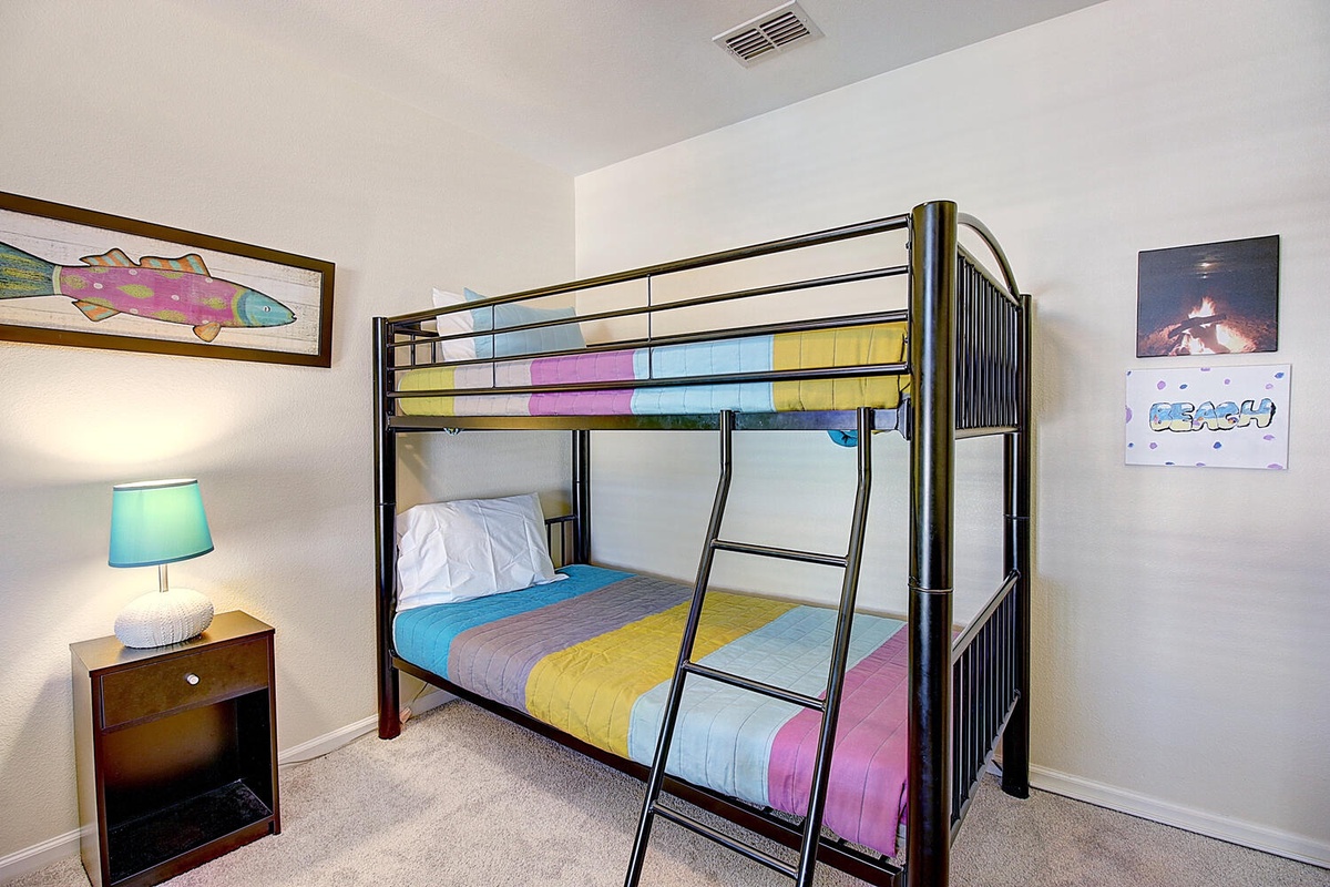 Your kids will love this cheerful bunk bed room with colorful bedding and playful artwork creating the perfect space for fun adventures.