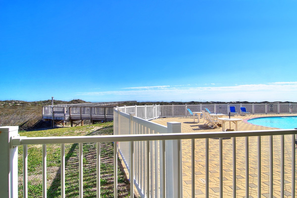 Enjoy your private balcony overlooking the pool deck, where crystal waters meet endless blue skies in your coastal retreat.