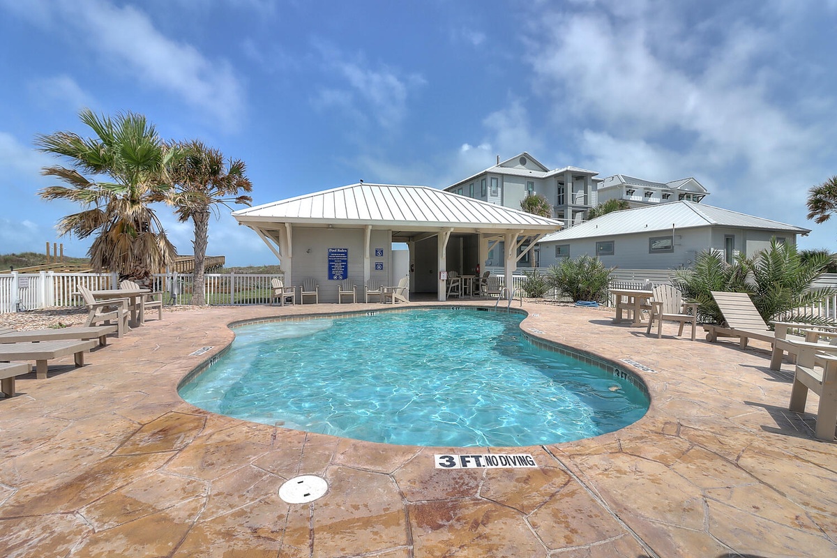 Dive into crystal-clear waters surrounded by swaying palms and coastal breezes in this tropical poolside paradise.