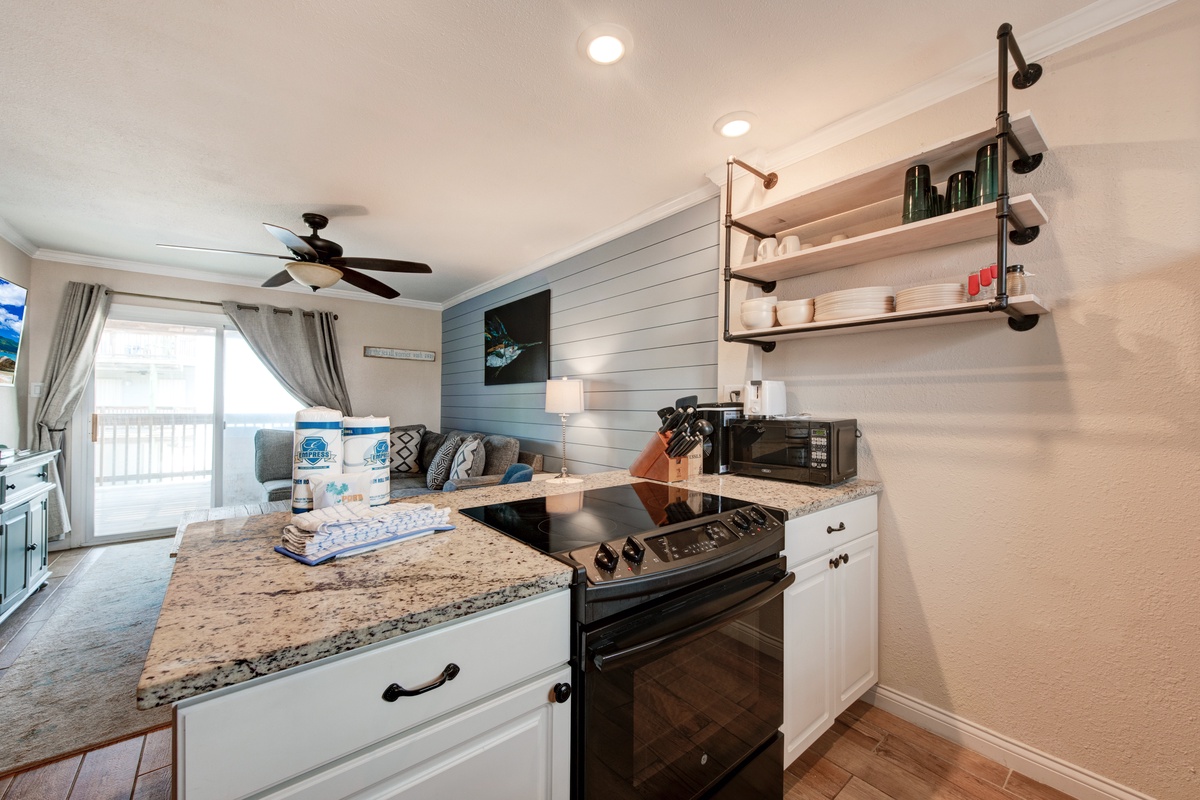 Your fully equipped kitchen features granite counters, modern appliances, and open shelving for easy meal prep.