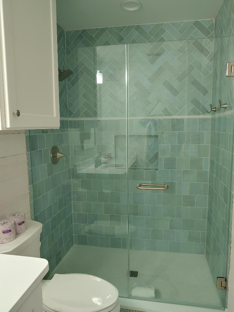 Step into your spa-like sanctuary with gorgeous sea-foam tile work and a rainfall shower that transforms daily routines into pure relaxation.