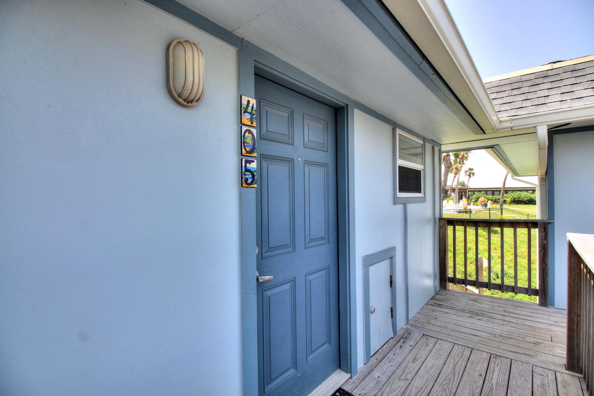Step onto your private balcony with charming blue door and peaceful views of the surrounding greenery.