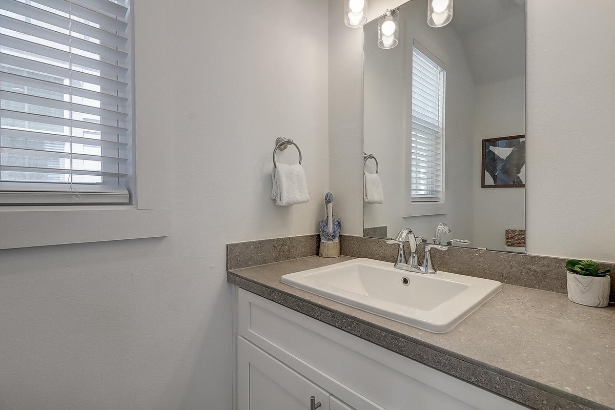Refresh in your elegant bathroom with modern lighting, pristine countertops, and thoughtful amenities for a comfortable stay.