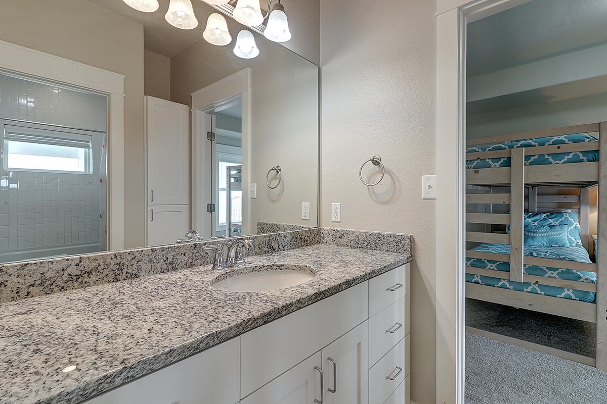 Your private bathroom features granite countertops and bright vanity lighting, with convenient access to the bunk bed room.