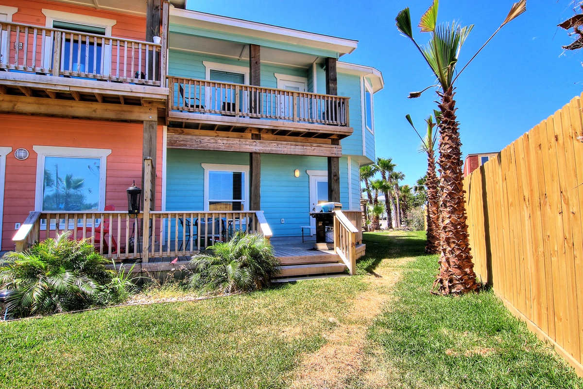 Colorful beach houses with tropical palms create a vibrant coastal retreat under clear blue skies.