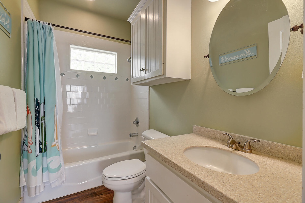 Step into your private bathroom oasis with soothing green walls, granite countertops, and a relaxing tub-shower combo.