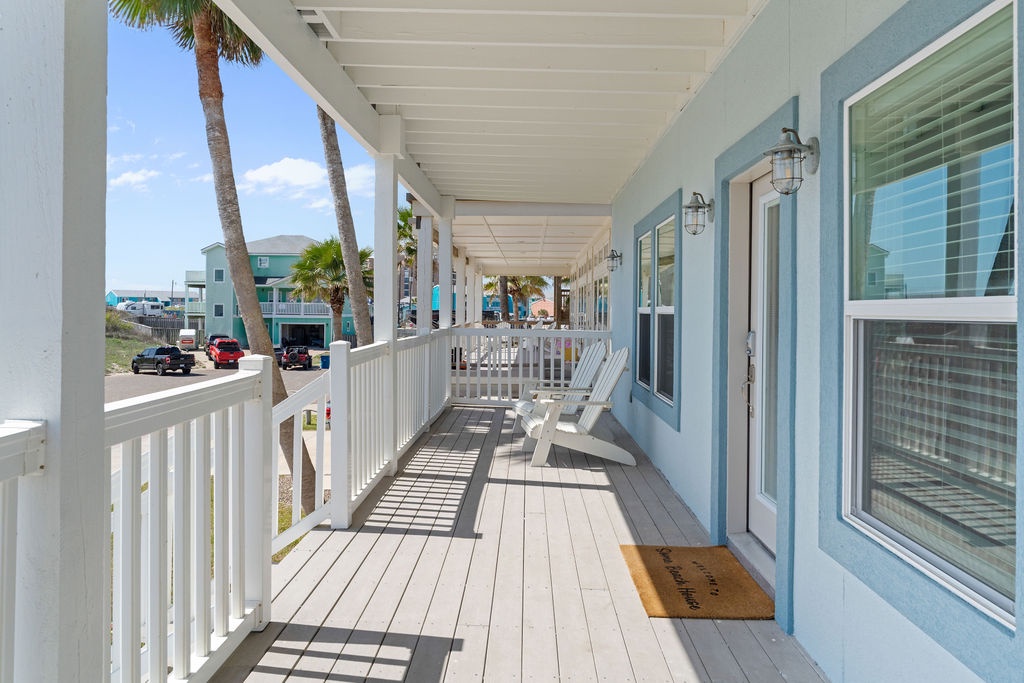 Your covered porch offers peaceful morning coffee spots with white rocking chairs overlooking swaying palms and coastal charm.