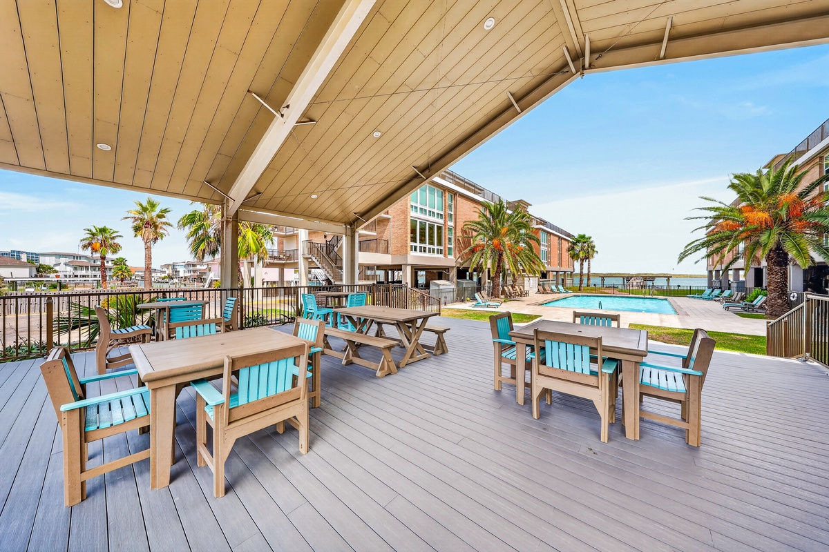 The community gathering space features ocean views, swaying palms, and a pool just steps away—your perfect spot to relax between beach adventures.