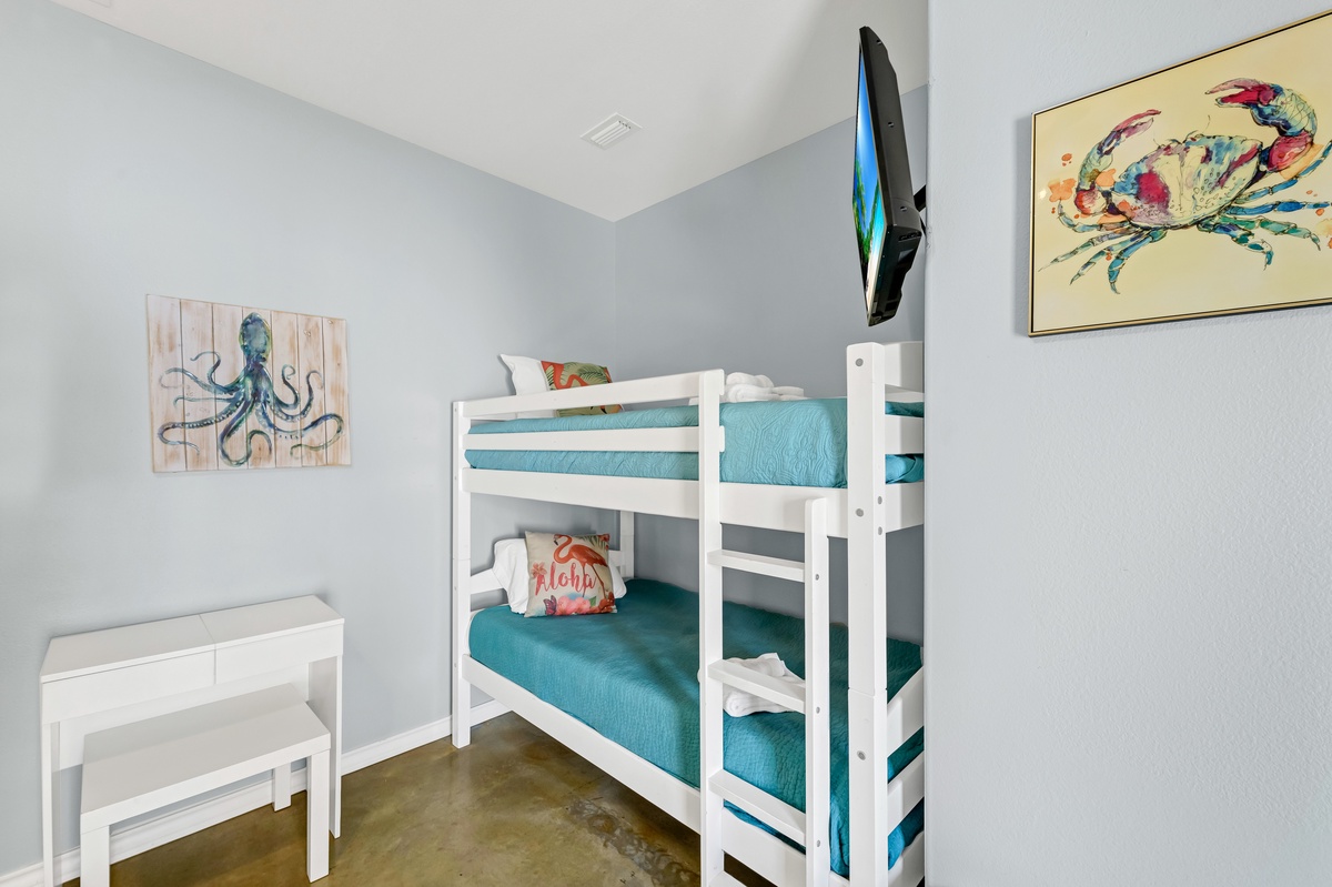 Your kids will love this ocean-themed bunk room, complete with nautical art and a wall-mounted TV for cozy movie nights.