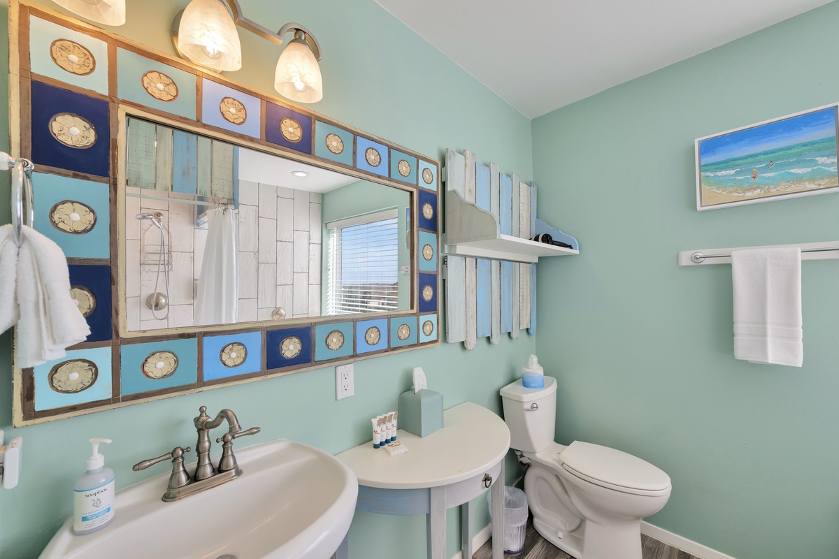 Step into your charming coastal bathroom where sea-inspired blues and soft mint walls create a peaceful retreat with fluffy towels awaiting.