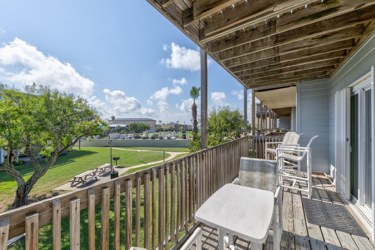 Relax on your private balcony with comfortable seating overlooking green lawns and peaceful surroundings.