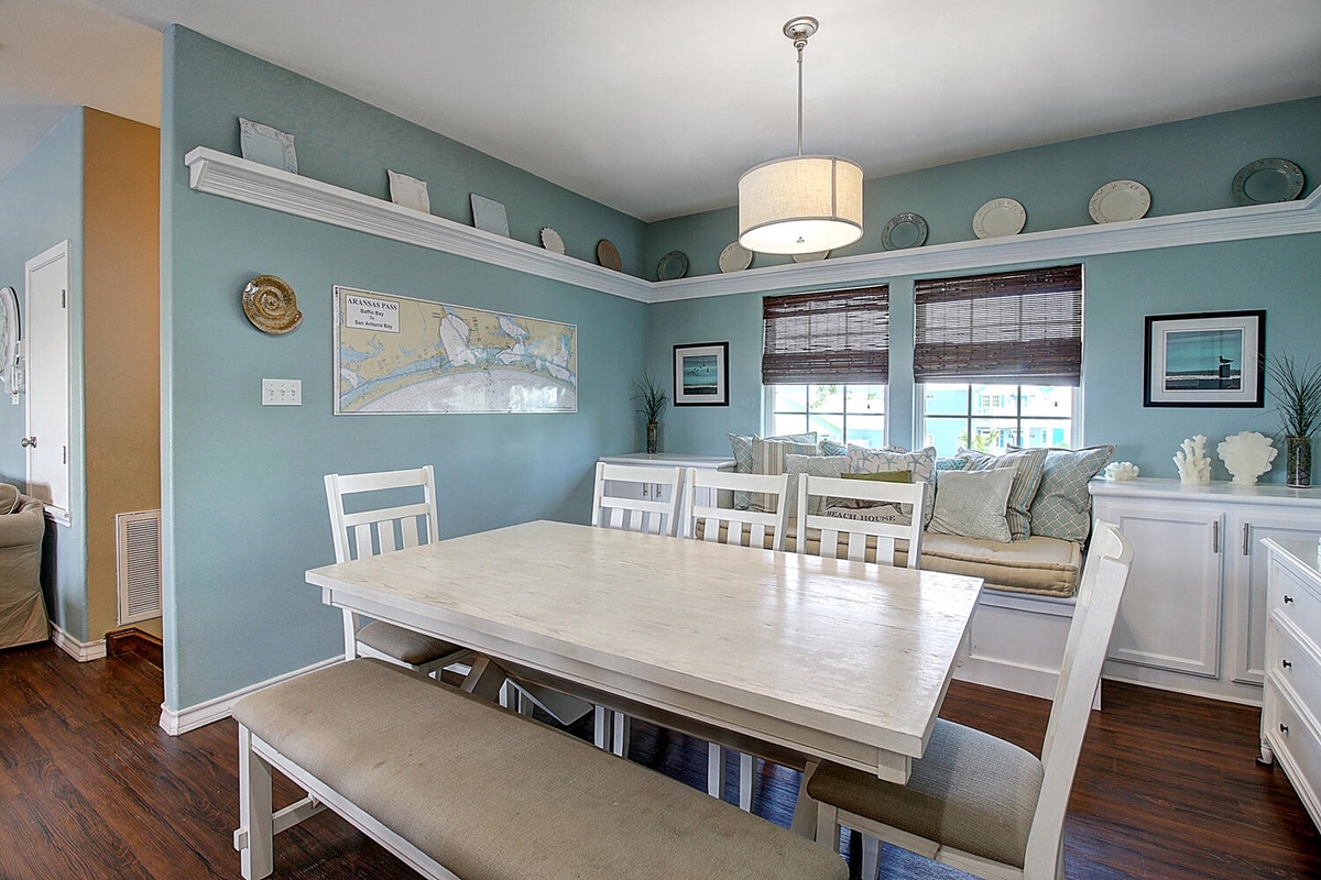 Gather around this coastal dining space where sea-blue walls and white furnishings create your perfect beachside dining experience.