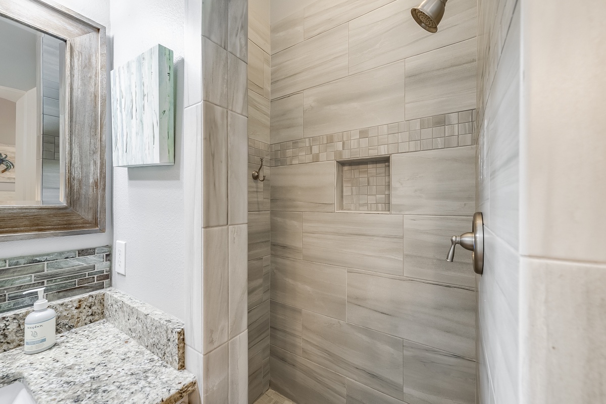 Step into your spa-like shower with elegant stone tiles and rainfall showerhead for a refreshing start to each day.