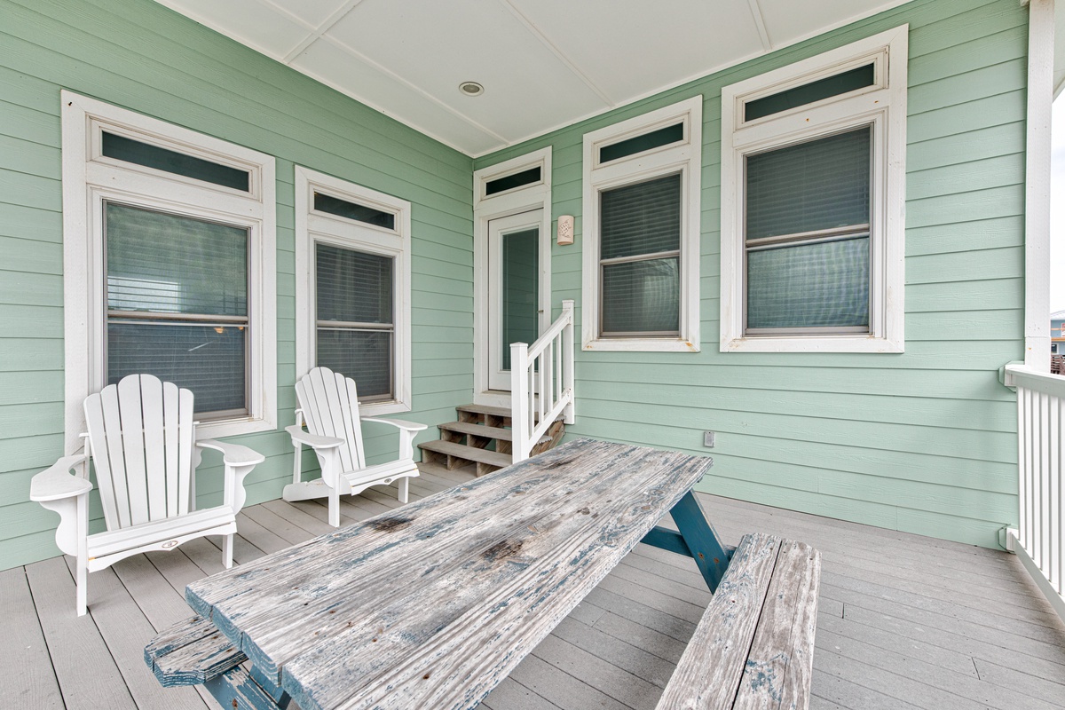 Your private covered porch beckons with Adirondack chairs and rustic picnic table—perfect for morning coffee or evening relaxation.