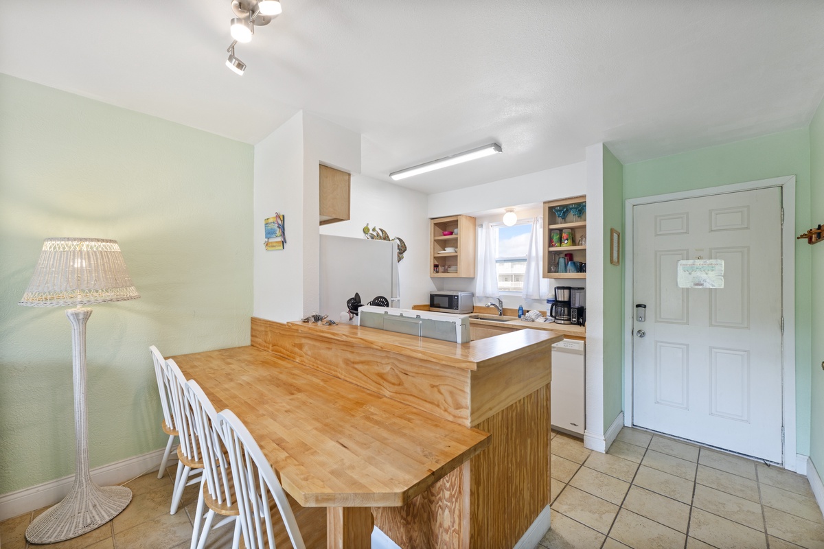 Your open kitchen features warm wood counters and breakfast bar seating, perfect for morning coffee and casual meals together.