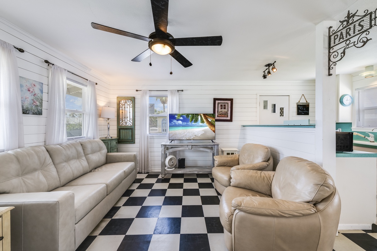 Settle into plush leather seating in your bright, retro-chic living space with classic checkered floors and ceiling fan to keep you cool and comfortable.
