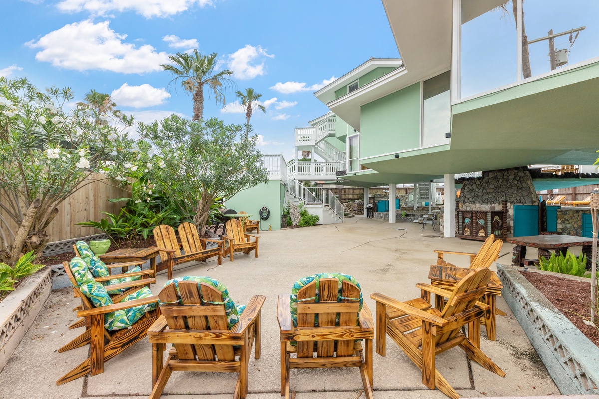 Relax in comfortable Adirondack chairs surrounded by tropical palms and lush gardens in this peaceful courtyard retreat.