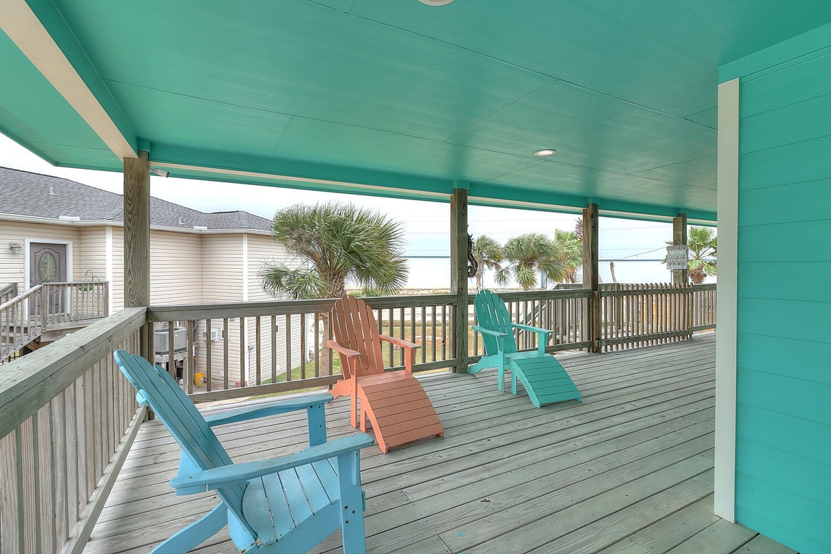 Relax in colorful Adirondack chairs on your covered deck, where tropical breezes and palm tree views create your perfect beach retreat.