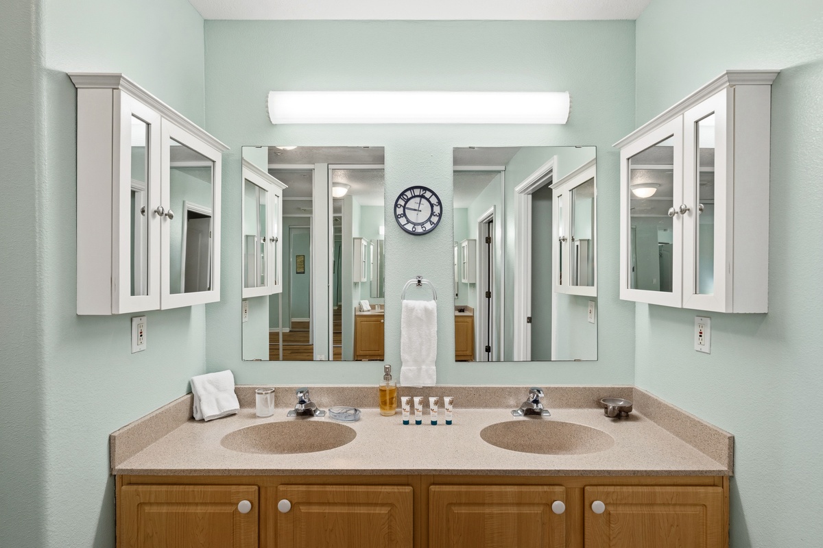 Freshen up at your dual-sink vanity with plenty of counter space and storage. The soft mint walls and bright lighting create a calming atmosphere for your morning routine.